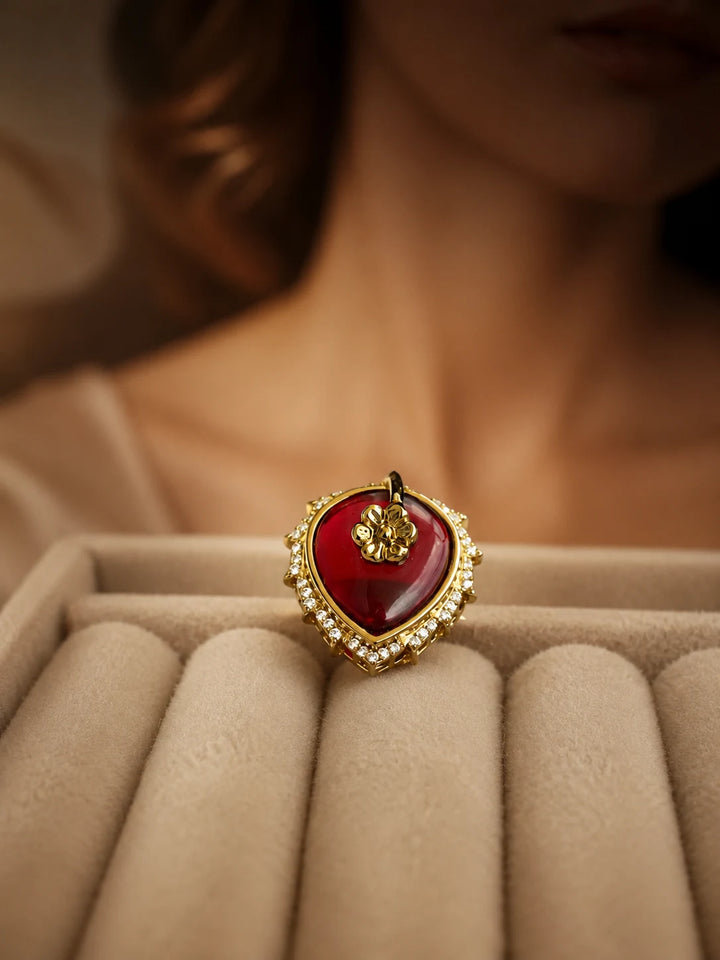 Maroon Heart Ring with gold-toned setting, deep heart-shaped center stone, floral top detail, and crystal-style border accents