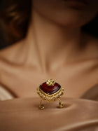 Maroon Heart Ring with gold-toned setting, deep heart-shaped center stone, floral top detail, and crystal-style border accents