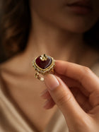 Maroon Heart Ring with gold-toned setting, deep heart-shaped center stone, floral top detail, and crystal-style border accents