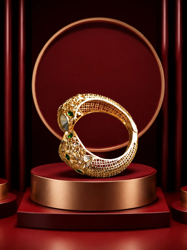 Green Kundan Kada with gold-toned floral cutwork, green stone accents, white kundan-style stones, and broad bracelet design