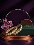 Green Kundan Bangles with gold-toned kada design, white kundan-style stones, green meenakari accents, and linked oval motifs