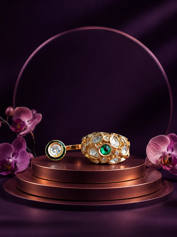 Kundan Two Finger Ring with green center stone, gold-toned statement design, white kundan-style stones, and round side motif