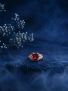Red Stone Ring with square red center stone, gold-toned band, and clear crystal-style side accents